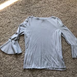 Powdery blue sweater with flowing detailed sleeves.